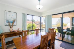 a dining room with a wooden table and chairs at Seahaven by Rockingham Apartments in Rockingham