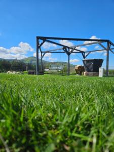 a gazebo in a field with green grass at Zacisze w Karkonoszach in Karpacz