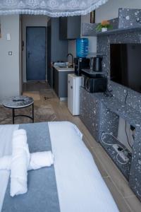 a bedroom with a bed and a kitchen with a tv at Taurus B8-6 in Nairobi