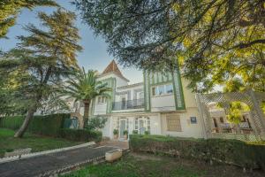 a large white house with a palm tree at Beneste Nerja Hostal in Nerja