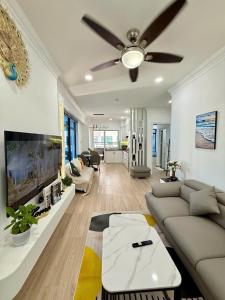 a living room with a couch and a ceiling fan at TA Nhatrang Apartment in Nha Trang