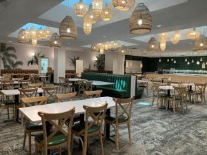 a dining room with tables and chairs and chandeliers at DoubleTree by Hilton at the Entrance to Universal Orlando in Orlando