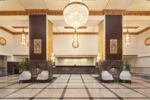 a lobby with a stage and chairs and a chandelier at Hilton Milwaukee in Milwaukee