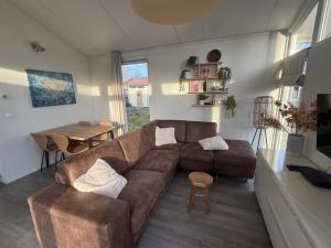 a living room with a brown couch and a table at Slechtvalk 7 in Hulshorst