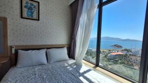 a bedroom with a bed and a large window at TA Nhatrang Apartment in Nha Trang