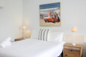 a bedroom with a white bed and an orange truck at Bay View - The Trio in Lorne