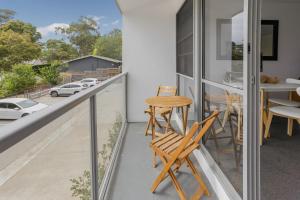 a balcony with chairs and a table and a view at Bay View - The Trio in Lorne