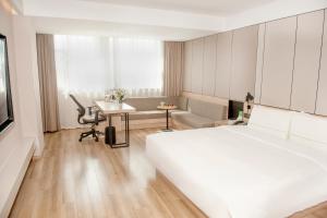a hotel room with a large bed and a desk at Atour Hotel High Speed Railway North Station Zibo Hi tech Zone in Zibo