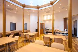 a dining room with tables and chairs and a kitchen at Hotel Bliss Villa Hasami in Hasami