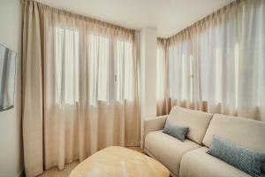 a living room with a couch and a large window at Beneste Nerja Hostal in Nerja