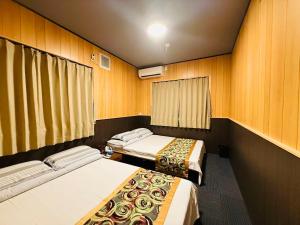 two beds in a room with wooden walls at Shanshui House TAKASHIMA 一棟貸切 自炊BBQok in Takashima