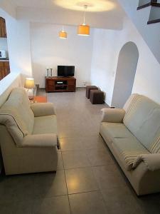 sala de estar con 2 sofás y TV en Casa do Cruzeiro, en Lagoa