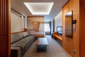 a living room with a couch and a tv at Hotel Sierra Resort Hakuba in Hakuba