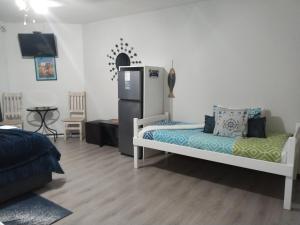 a room with a bed and a refrigerator in it at Ryans Surf Cabin in Jeffreys Bay