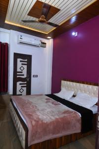 a bedroom with a large bed with a purple wall at Hotel Royal Vista in Meerut