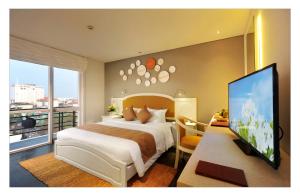 a bedroom with a large bed and a television at Alba Spa Hotel in Hue