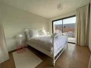 a bedroom with a white bed and a large window at luxe et sérénité in Lecci +15 photos