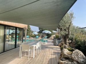 a patio with a table and chairs and a pool at luxe et sérénité in Lecci
