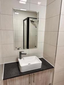 a bathroom with a sink and a mirror at SouthSide Apartment in Gaborone +21 photos