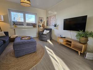 a living room with a large flat screen tv at Küstenglück 2 Stylisches Apartment mit Meerblick - 200m zum Strand & Bäcker in Dahme