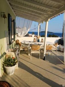 a patio with a table and chairs on a house at Thea Rooftop in Skiathos
