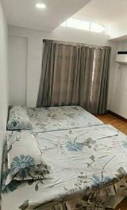 a bed in a bedroom next to a window at Thai Nee Homestay in Manila