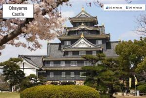 a large building with a sign that reads okayama castle at ura 花れ -hanare- in Okayama