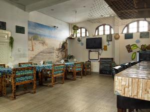 a restaurant with tables and chairs and a flat screen tv at Captain Purunchi in Cotonou