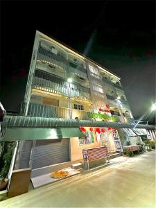 a tall building with a bench in front of it at อมรรัตน์Room in Pathum Thani
