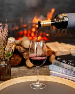 a person pouring red wine into a wine glass at The Bay Hotel in Cape Town