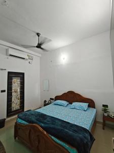 a bedroom with a bed with a blue comforter at Shivprasad homestay in Varanasi