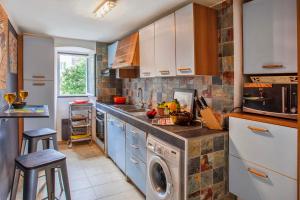 a kitchen with blue cabinets and a washer and dryer at Casa Erbalunga Au cœur du village proche du port et de la plage in Erbalunga +9 photos