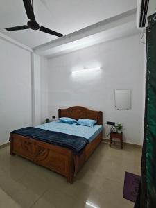a bedroom with a wooden bed with blue pillows at Shivprasad homestay in Varanasi +15 photos