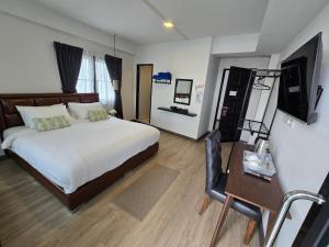 a bedroom with a bed and a desk and a television at Charma Home Watket in Chiang Mai