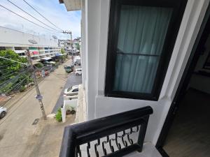 a balcony with a window with a view of a street at Charma Home Watket in Chiang Mai