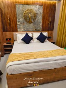 ein Schlafzimmer mit einem Bett mit blau-weißen Kissen in der Unterkunft HOTEL ABHIJIt in Kolaghat + 27 Fotos