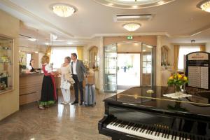 Ein Mann und eine Frau stehen in einer Lobby mit einem Klavier in der Unterkunft Ringhotel Winzerhof in Rauenberg
