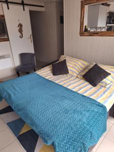 a bedroom with a bed with a blue comforter at Gîte l'hippocampe in Jarjayes