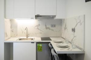 a kitchen with white marble walls and a sink at Coastline 1 in Perea +86 photos