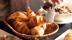a basket of pastries and a person holding a fork at Ambiance Resort Hunza in Hunza Valley +36 photos