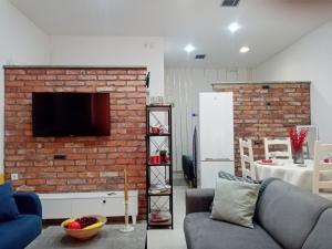 a living room with a couch and a brick wall at Sava & Double Rooms in Prijedor +14 photos