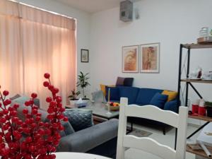 a living room with a blue couch and a table at Sava & Double Rooms in Prijedor