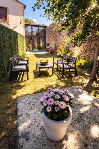 a patio with two benches and a pot of flowers at O Cabanel in Fisterra