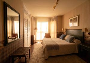 a hotel room with a bed and a mirror at Hotel Avenida Real in Villaviciosa