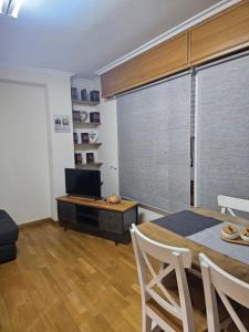 a living room with a dining table and a television at apartamento castelao in Cedeira