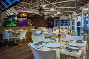 a dining room with white tables and white chairs at Glendower View Guest House in Johannesburg