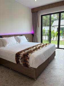 a bedroom with a large bed with a large window at Tiger on the Beach in Krabi