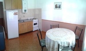 eine Küche mit einem Tisch und eine Küche mit einem Kühlschrank in der Unterkunft La Colonial Cabañas in Villa Cura Brochero
