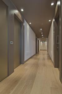 an empty hallway with wooden floors in an office building at Zen Hotel Versilia in Marina di Pietrasanta