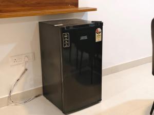 a black refrigerator sitting on the floor next to a wall at Hotel Vamshi Grand in Lingampalli